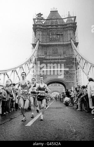 I concorrenti attraversano il Tower Bridge per raggiungere la tappa a metà strada della prima maratona di Londra. Foto Stock