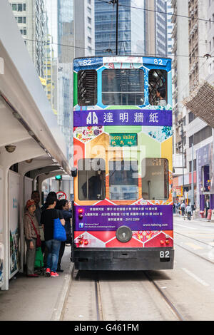 Hong Kong, Cina - 30 Marzo 2015: i passeggeri a bordo di un tram elettrico su Des Voeux Road nel quartiere centrale di Hong Kong. Foto Stock