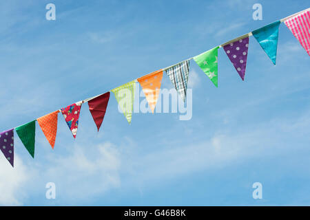 Colorato tessuto retrò bunting contro blu cielo molto nuvoloso in Cotswolds. Regno Unito Foto Stock