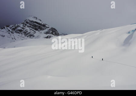 Due ski Tourer di avventurarsi su un grande ghiacciaio in British Columbia, mentre si avvicina una tempesta Foto Stock