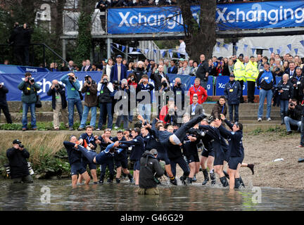 Oxford cox's Zoe De Toledo (equipaggio Isis) e Sam Winter-Levy (equipaggio Blue Boat) vengono gettati in acqua dopo che Oxford ha battuto Cambridge nella 157a gara di barche sul fiume Tamigi, Londra. Foto Stock