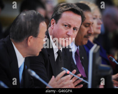 Il primo Ministro britannico David Cameron ascolta il discorso del Segretario Generale delle Nazioni Unite Ban Ki Moon all'apertura della Conferenza libica a Londra. Foto Stock