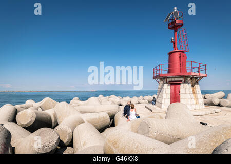 Faro rosso che indica l'entrata del porto. Foto Stock