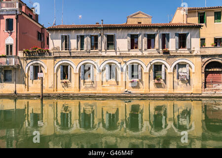 Pittoreschi edifici sui lati di un canale a Chioggia, laguna di Venezia. Foto Stock