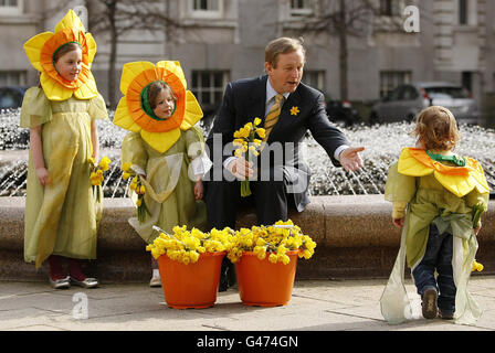 Taoiseach Enda Kenny siede presso la fontana con Isobel Aherne, sei, Millie Aherne, quattro e due anni Orlaith Power in edifici governativi durante il lancio del Daffodil Day in aiuto della Società Irlandese del cancro. Foto Stock