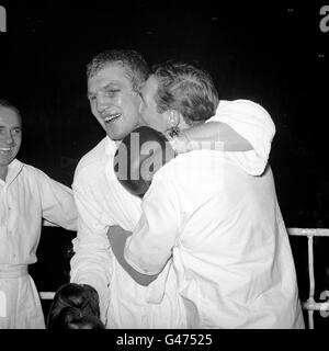 Jubilant West Ham Heavyweight Billy Walker ottiene un bacio gioioso da suo fratello George, che è anche il suo manager, dopo aver sconfitto Joe Erskine di Cardiff Foto Stock