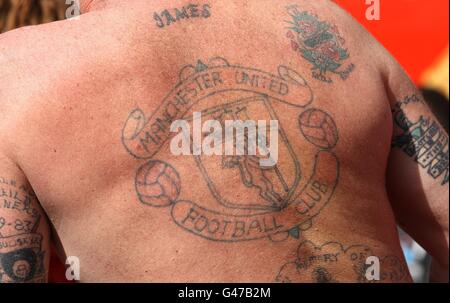 Un fan con un grande tatuaggio di cresta del Manchester United club sulla schiena
