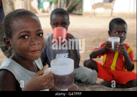 KENYA Turkana regione, campo di rifugiati di Kakuma, dove 80.000 rifugiati vivono, il Servizio dei Gesuiti per i rifugiati a scuola i bambini a bere durante la pausa Foto Stock