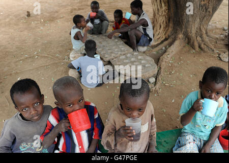 KENYA Turkana regione, campo di rifugiati di Kakuma, dove 80.000 rifugiati vivono il JESUIT REFUGEE SERVICE school , i bambini a bere e giocare una partita su pietra Foto Stock