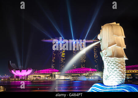 SINGAPORE - Ottobre 3, 2012: Singapore la statua Merlion veglia su di luci laser proveniente dalla Marina Bay Sands Hotel. Foto Stock