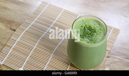 Tè Verde Matcha Smoothie stemless in vetro sul tappetino di bambù sulla tavola da angolo sopra l'orientamento orizzontale Foto Stock