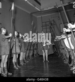 L'ex Sergente Regimental Major Ronald Brittain, centro, mette un gruppo di reclute 'Roman' attraverso i loro movimenti di perforazione alla Bedford School, Holborn Boys Club, Londra. Britain sta usando la sua famosa voce forte per addestrare 32 ex Guardmen che compariranno nell'uniforme dei centurioni romani alla premiere di beneficenza del film 'Sparacus'. Foto Stock