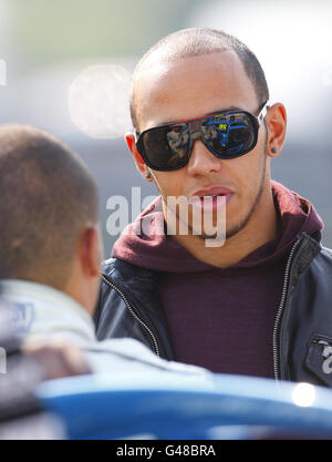 L'ex campione di Formula uno Lewis Hamilton chiacchiera con il fratello Nicolas (a sinistra) che gareggia nella Renault Clio Cup al circuito di Thruxton, Andover. Foto Stock