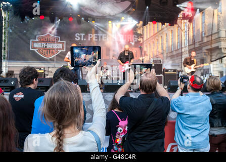 Gli spettatori la ripresa di un concerto rock band sui vostri dispositivi mobili Foto Stock