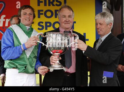 Jockey Jamie Codd (a sinistra) festeggia con il trofeo e l'allenatore J P Dempsey (a destra) dopo aver vinto il KFM Hunters Chase Per la Coppa Vishopscourt sulla rotopressa Foto Stock