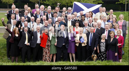 Il leader della SNP Alex Salmond e il vice leader della SNP Nicola Sturgeon con i nuovi membri della SNP al di fuori del Parlamento scozzese a Edimburgo, dopo la vittoria senza precedenti della SNP alle elezioni del Parlamento scozzese. Foto Stock