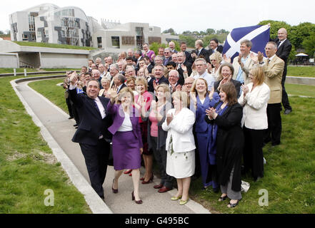 Il leader della SNP Alex Salmond e il vice leader della SNP Nicola Sturgeon con i nuovi membri della SNP al di fuori del Parlamento scozzese a Edimburgo, dopo la vittoria senza precedenti della SNP alle elezioni del Parlamento scozzese. Foto Stock