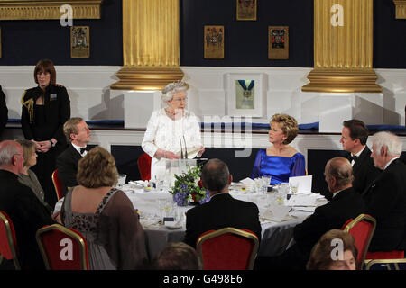 La Regina Elisabetta II della Gran Bretagna ha tenuto il suo discorso al Castello di Dublino, seguito da un Taoiseach Enda Kenny (seduto a sinistra) e dal presidente irlandese Mary McAleese (a destra) durante una cena di stato il secondo giorno della sua visita di Stato in Irlanda. Foto Stock