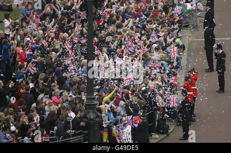 I confetti vengono gettati dalla folla riunita fuori Buckingham Palace per il matrimonio del principe William e di Catherine Middleton all'abbazia di Westminster. Foto Stock