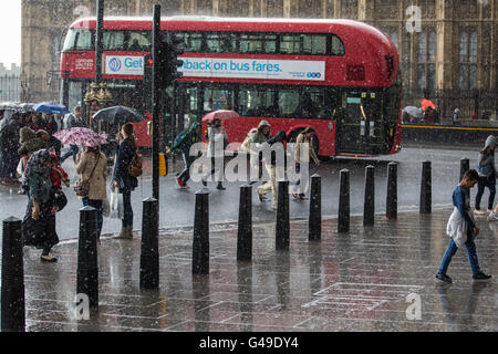 Londra, Regno Unito. 14 Giugno, 2016. I turisti girare per copertura attraverso il terrapieno da Westminster Bridge durante un improvviso cloudburst. Foto Stock