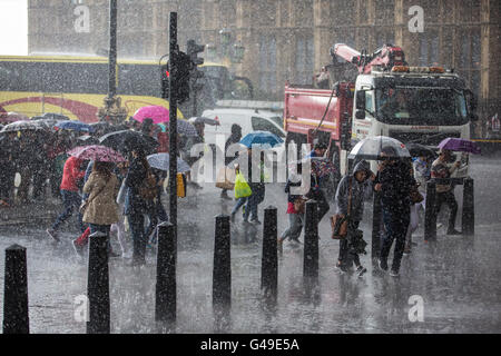 Londra, Regno Unito. 14 Giugno, 2016. I turisti girare per copertura attraverso il terrapieno da Westminster Bridge durante un improvviso cloudburst. Foto Stock