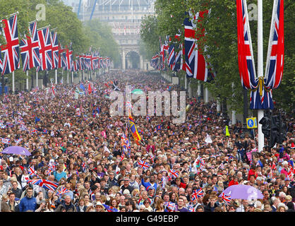 La folla è condotta lungo il Mall verso Buckingham Palace, Londra, dopo il matrimonio del Principe William e Kate Middleton all'Abbazia di Westminster. Foto Stock