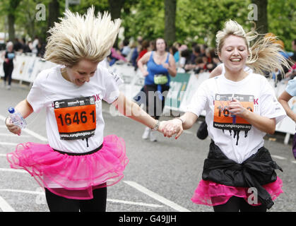 I runner festeggiano mentre attraversano il traguardo durante la 10k delle donne di gestione degli asset a Glasgow, Scozia. Foto Stock