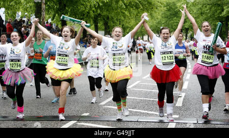 I runner festeggiano mentre attraversano il traguardo durante la 10k delle donne di gestione degli asset a Glasgow, Scozia. Foto Stock