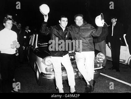 Un'ondata felice dai vincitori svedesi, il co-driver Gunner Palm (a sinistra) e Bengt Soderstom (a destra), di fronte al loro Lotus Cortina, all'aeroporto di Londra Foto Stock