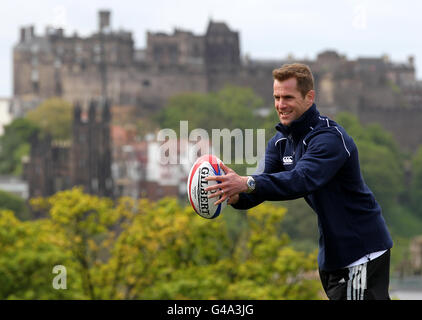 Il giocatore di rugby scozzese Chris Paterson aiuta a lanciare la gamba scozzese della torcia olimpica di Londra 2012 su Calton Hill a Edimburgo, Scozia. Foto Stock