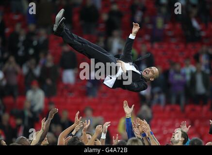 Il manager di Barcellona Josep Guardiola è gettato in aria da I suoi giocatori dopo aver vinto la finale della UEFA Champions League Foto Stock