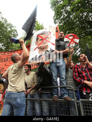 I musulmani provenienti da tutto il Regno Unito manifestano al di fuori dell’ambasciata siriana a Belgrave Square, nel centro di Londra, dopo una manifestazione organizzata da Hizb ut-Tahrir, in solidarietà con la popolazione che si erge in tutto il mondo arabo e musulmano. Foto Stock