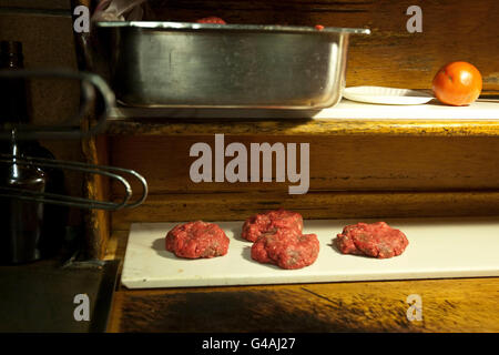 Patties di Hamburger attendere di essere grigliate a Louis' PRANZO in New Haven, CT, Stati Uniti d'America, 26 maggio 2009. Foto Stock