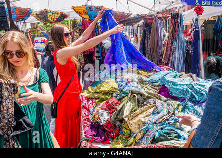 Donne scorazzare vestiti nel mercato all'aperto, di stallo Foto Stock