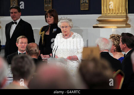 La Regina Elisabetta II della Gran Bretagna parla al Castello di Dublino, guardato da un Taoiseach Enda Kenny (seduto a sinistra) durante una cena di Stato il secondo giorno della sua visita di Stato in Irlanda. Foto Stock