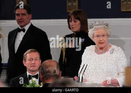 La Regina Elisabetta II della Gran Bretagna parla al Castello di Dublino, guardato da un Taoiseach Enda Kenny (seduto a sinistra) durante una cena di Stato il secondo giorno della sua visita di Stato in Irlanda. Foto Stock