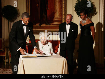 La regina Elisabetta II firma il libro degli ospiti mentre lei fa il congedo al presidente degli Stati Uniti Barack Obama e alla prima signora Michelle Obama, guardato dal duca di Edimburgo a Winfield House - la residenza dell'ambasciatore degli Stati Uniti d'America - a Regent's Park, Londra. Foto Stock