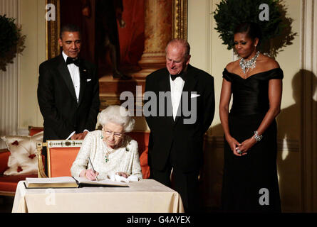 La regina Elisabetta II firma il libro degli ospiti mentre lei fa il congedo al presidente degli Stati Uniti Barack Obama e alla prima signora Michelle Obama, guardato dal duca di Edimburgo a Winfield House - la residenza dell'ambasciatore degli Stati Uniti d'America - a Regent's Park, Londra. Foto Stock