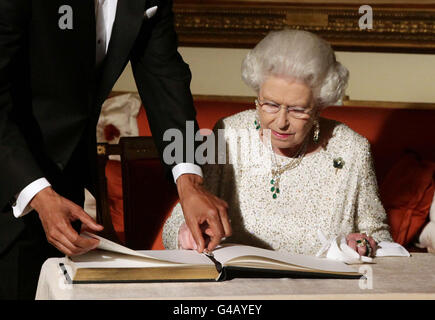 La regina Elisabetta II firma il libro dell'ospite mentre addio il presidente americano Barack Obama e la prima signora Michelle Obama a Winfield House - la residenza dell'ambasciatore degli Stati Uniti d'America - in Regent's Park, Londra. Foto Stock