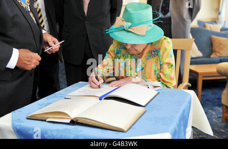 La Regina Elisabetta II firma il libro dei visitatori al Tregarthan's Hotel a Hugh Town St Mary's Island nelle isole di Scilly durante la sua visita di oggi. Foto Stock