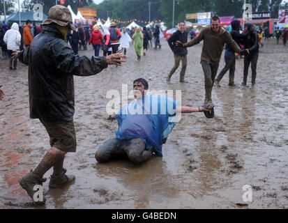 Isola di Wight Festival 2011. Festival goers nel fango durante l'ultimo giorno del Festival dell'Isola di Wight. Foto Stock