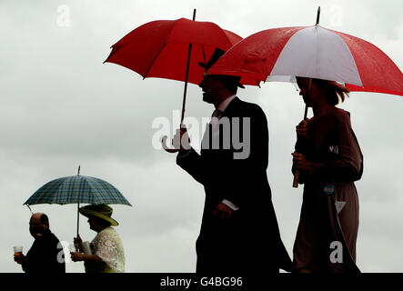 Corse di cavalli - il Royal Ascot Meeting 2011 - Day Four - Ascot Racecourse. Racegoers riparo dalla pioggia sotto gli ombrelloni il giorno quattro del Royal Ascot Meeting presso Ascot Racecourse, Berkshire. Foto Stock