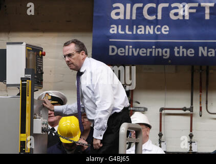 Il Segretario alla Difesa Liam Fox taglia il primo acciaio per una nuova portaerei, durante una visita al cantiere navale BAE Systems di Govan, Scozia. Foto Stock