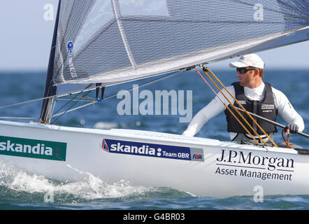 Vela - vela Skandia per la regata d'oro - giorno uno. Medaglia d'oro tre volte olimpica ben Ainslie in azione nella sua dinghia finlandese durante il giorno uno della vela Skandia per la regata d'oro nel Dorset. Foto Stock