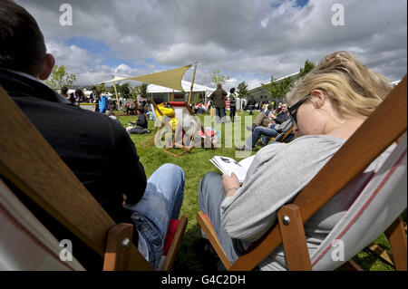 Festa del fieno. La gente si rilassa nel mutevole clima del fine settimana delle feste di banca al Festival di Hay-on-Wye, Powys, Galles. Foto Stock