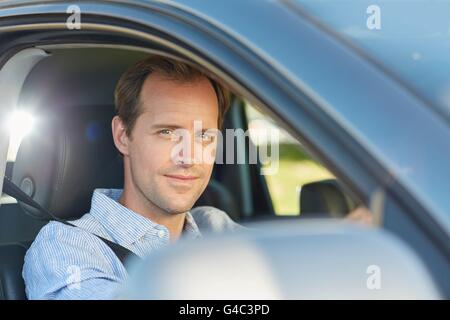 Modello rilasciato. Metà uomo adulto in auto, sorridente. Foto Stock