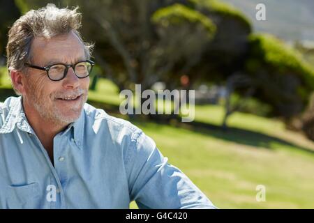 Modello rilasciato. L'uomo anziano con gli occhiali e camicia, sorridente. Foto Stock