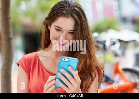 Modello rilasciato. Giovane donna utilizza lo smartphone. Foto Stock
