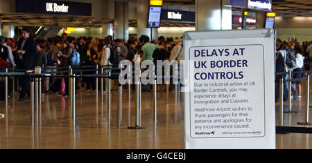 Code al controllo di frontiera nel terminal 5 dell'aeroporto di Heathrow di Londra, dove alcuni membri del personale addetto all'immigrazione e alla dogana si sono Uniti a una giornata di scioperi di insegnanti, funzionari pubblici e altri lavoratori contro i piani del governo per cambiare le pensioni, tagliare posti di lavoro e congelare la retribuzione. Foto Stock