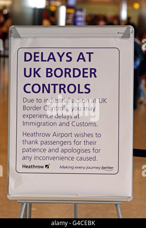 Un cartello al controllo di frontiera nel terminal 5 dell'aeroporto di Heathrow, dove alcuni addetti all'immigrazione e alle dogane si sono Uniti a una giornata di scioperi di insegnanti, funzionari pubblici e altri lavoratori per quanto riguarda i piani del governo di cambiare le pensioni, tagliare i posti di lavoro e congelare i salari. Foto Stock